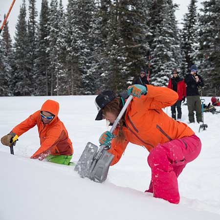Avi Level 2 instructor demonstrating snow-pit digging technique.