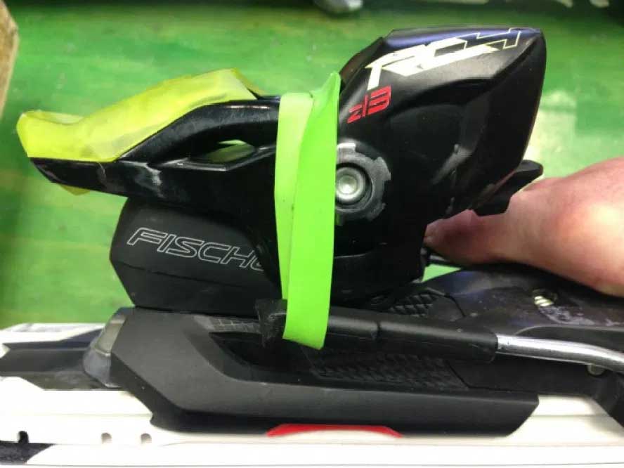 Ski technician brushes a pair of skis. 