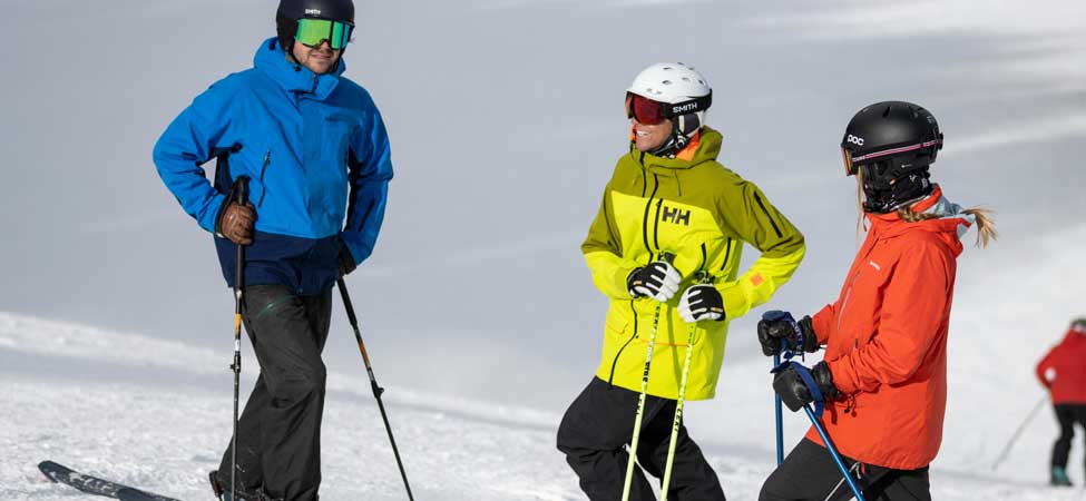 Three skiers stand at the top of a run at Deer Valley Resort in Park City, Utah.