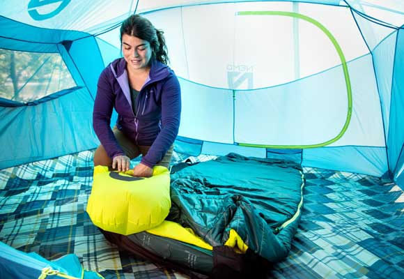 A camper filling their insulated inflatable sleeping pad. Image courtesy of Nemo.