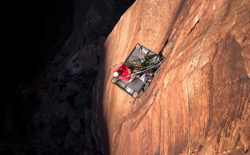 A climber resting on a portaledge while on a big wall route. Image courtesy of Black Diamond.