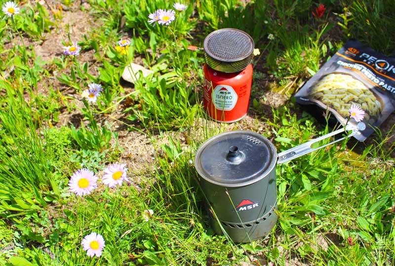 A MSR backpacking canister stove with the integrated cooking pot that fits over the burner.