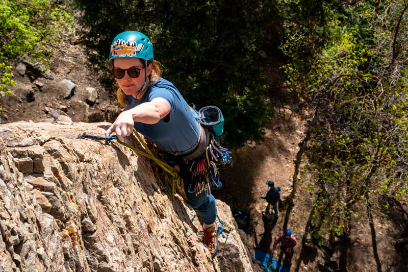 Jans expert clips her rope to a quickdraw while sport climbing in Utah.