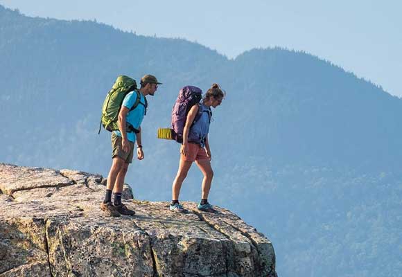 Two backpackers look at a mountain view. Image courtesy of Osprey.