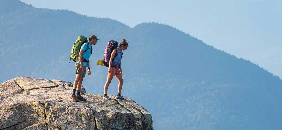 Two backpackers look at a mountain view. Image courtesy of Osprey.