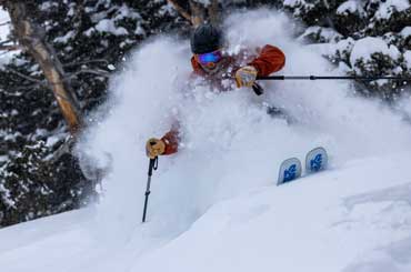 Jans Expert, Chris Norwood, skis through deep powder in the trees at Solitude Resort, Big Cottonwood Canyon, UT
