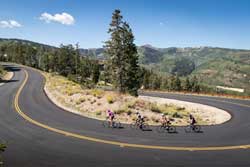 Road bike guide and clients round a turn on a scenic road above Park City, Utah.