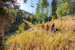 A guided hiking tour group makes their way through the fall leaves underneath a chairlift at Deer Valley Resort in Park City, Utah.