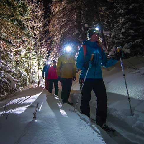 Jans guide Cindi Grant leads a moonlight snowshoe tour in Empire Canyon in Park City, Utah.