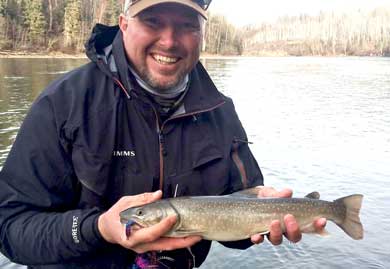 Jans fly fishing guide, Travis Vernon, posing with a brook trout cause on a lake in northern Utah.