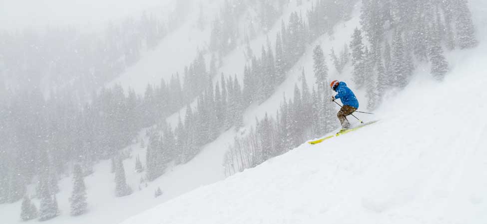 A single skier skiing powder on a stormy day in Park City, UT