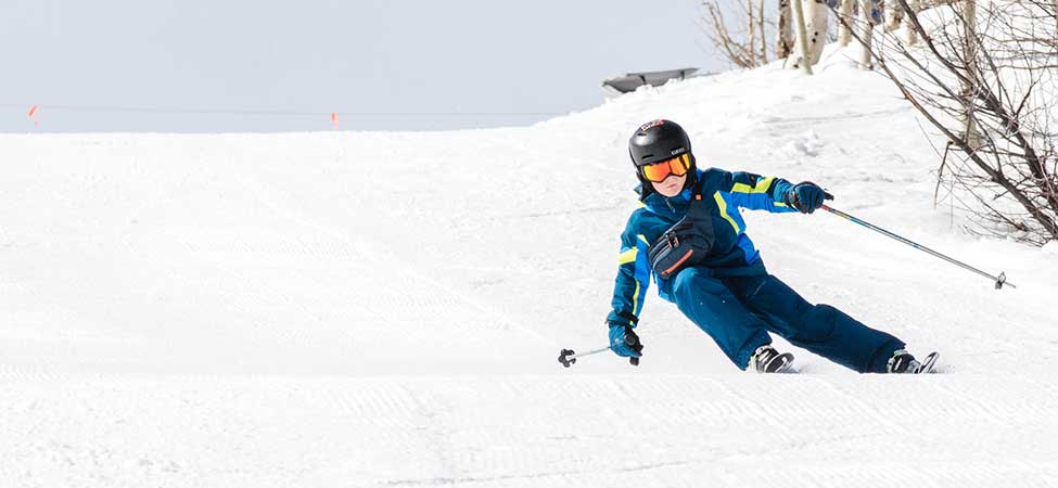 A young skier carves a turn on a groomed run in Park City, UT