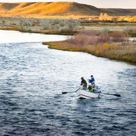 Guide and clients fish the Green River in Wyoming from a drift boat.