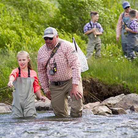 Jans fly fishing guide Travis Vernon helps a member of a group with their cast.