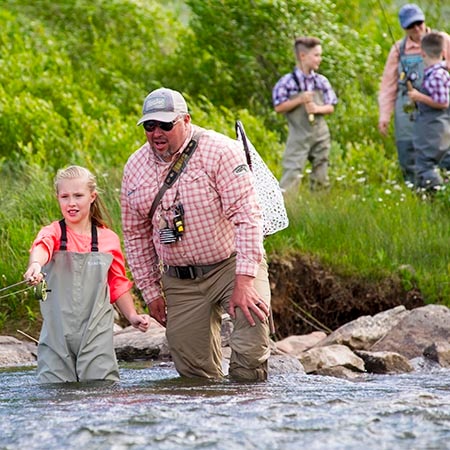 Jans fly fishing guide Travis Vernon helps a member of a group with their cast.