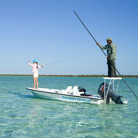 Client fly fishing for bonefish in clear blue waters off of Andros Island in the Bahamas.